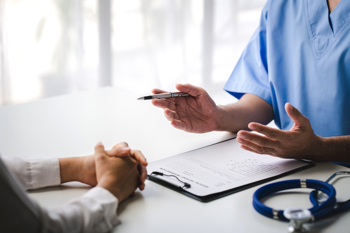 Healthcare provider consulting with a patient or medical professional about healthcare administration and practice support services.