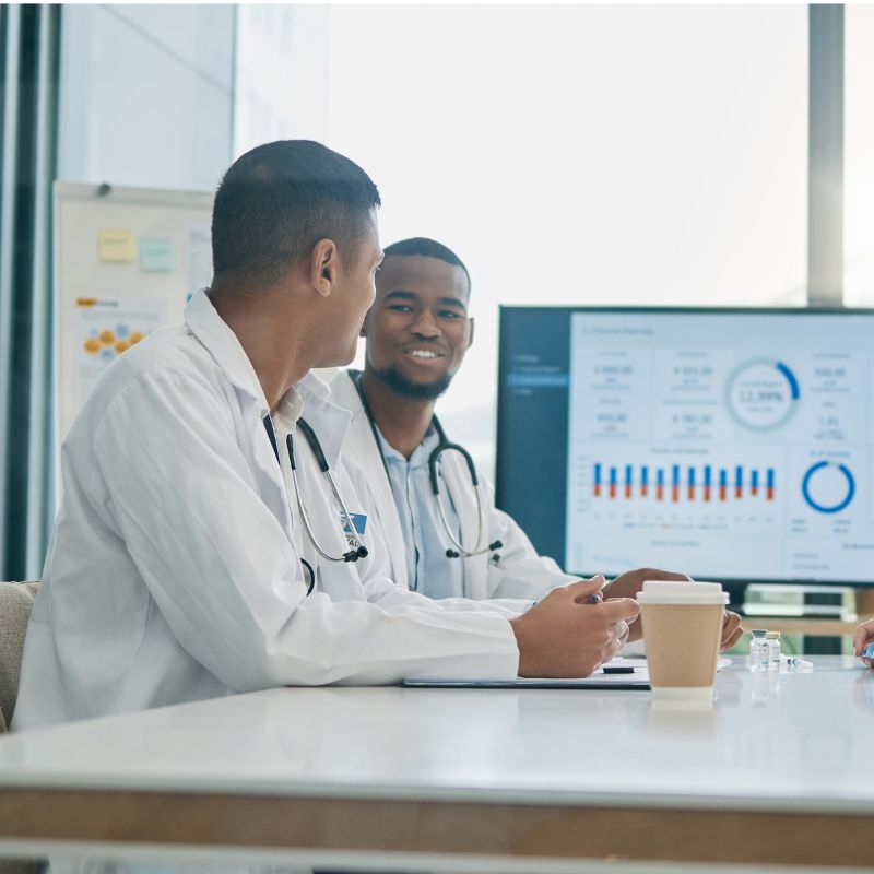 Healthcare consultants reviewing medical practice performance data and healthcare management analytics